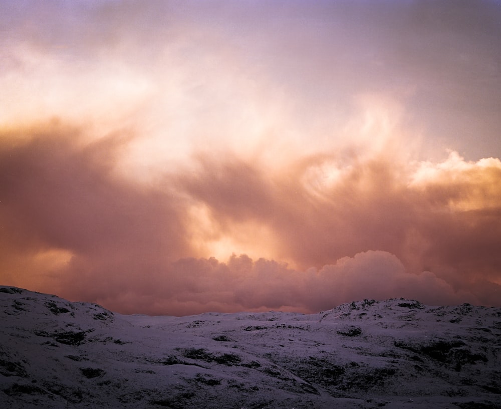 mountain covered with snow under cloudy sky