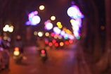 Blurred city lights coming into sharp focus through a camera lens.