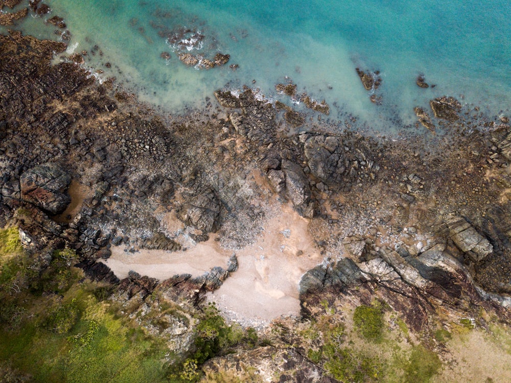 aerial photo of body of water beside cliff