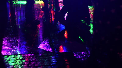 Urban street scene with colorful reflections on wet pavement.