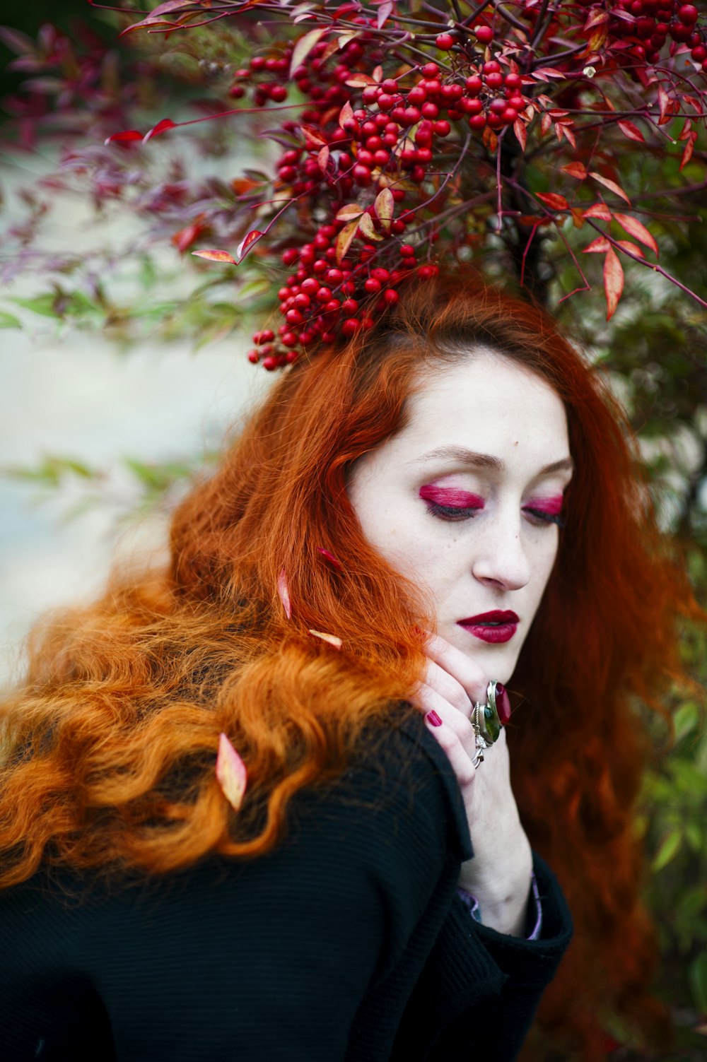 femme portant une veste noire debout sur des fruits rouges