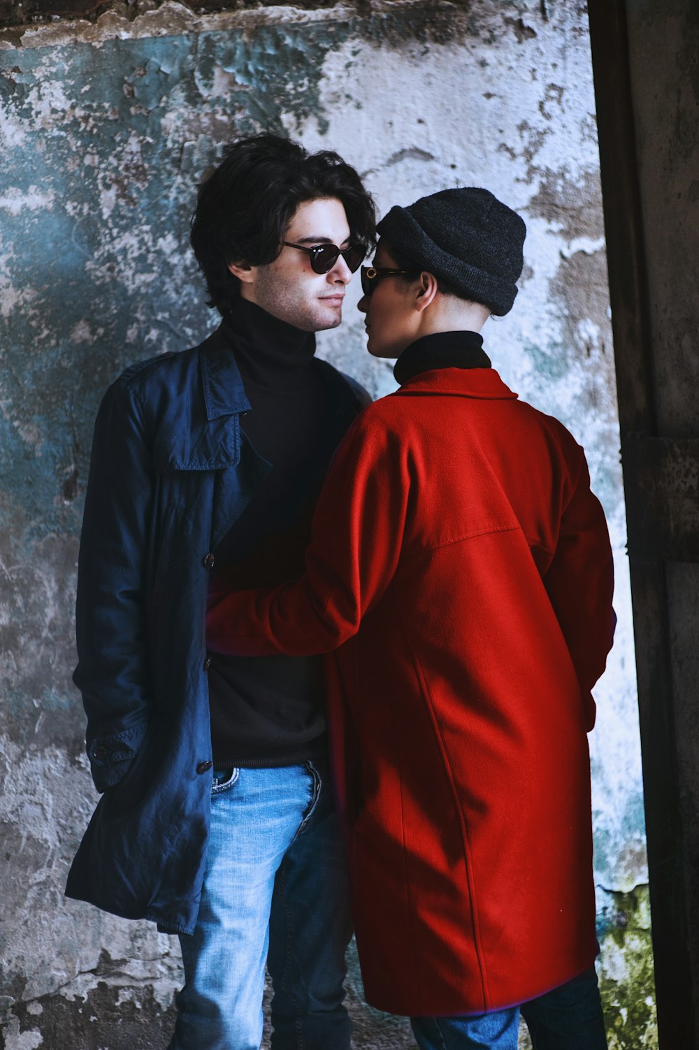 woman hugging man beside wall