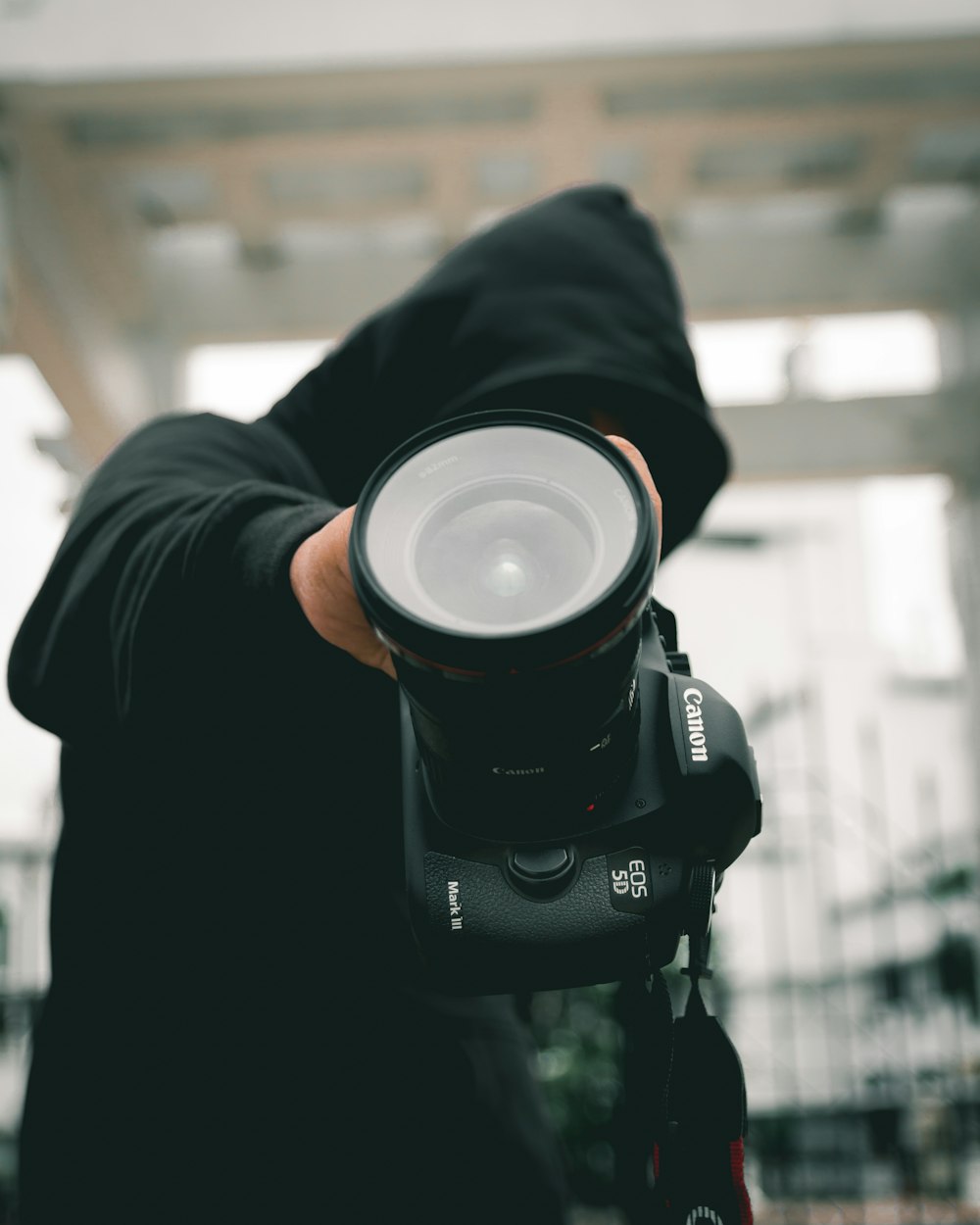 person holding black Canon EOS 5D DSLR camera