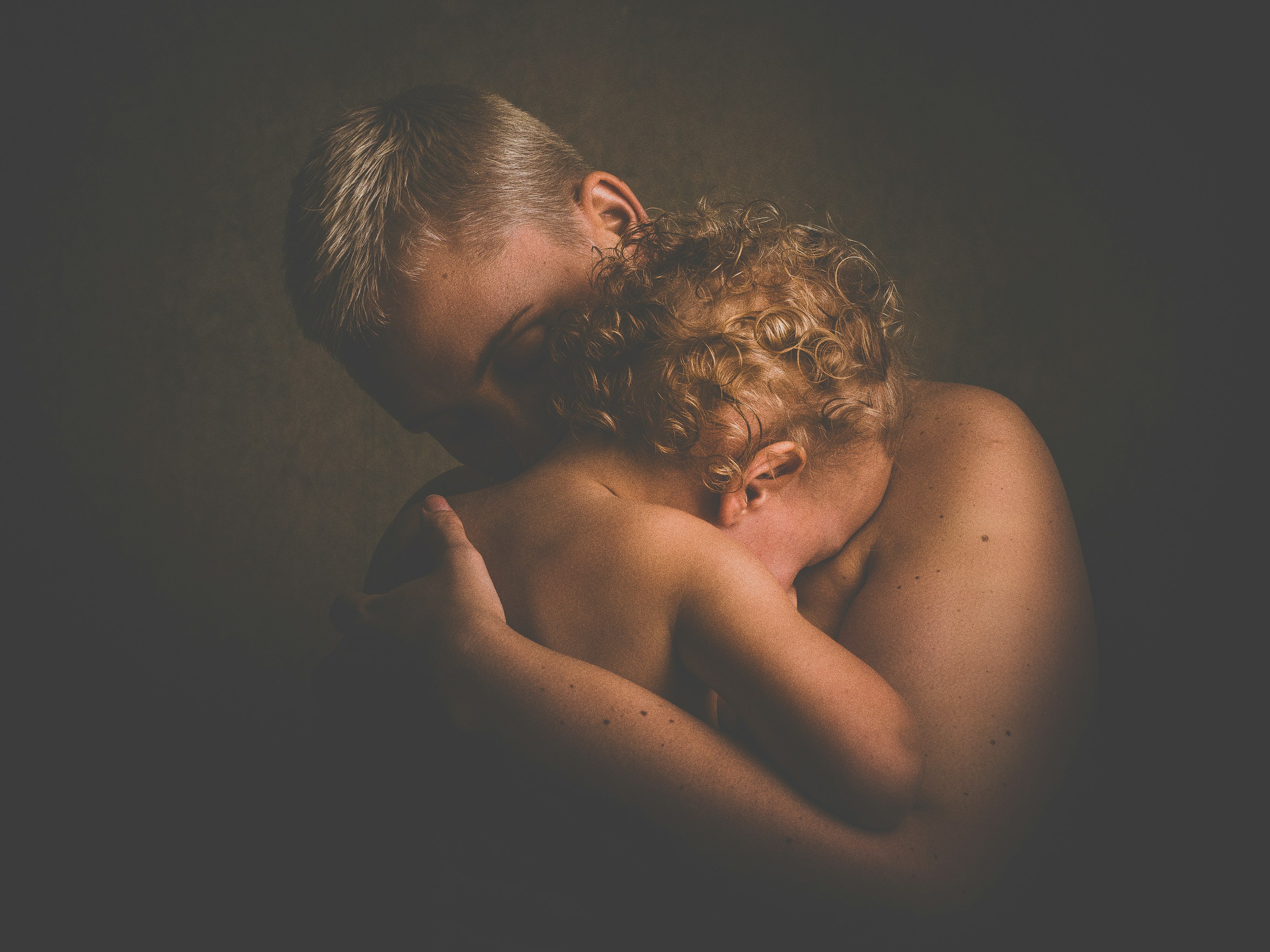 topless person carrying children