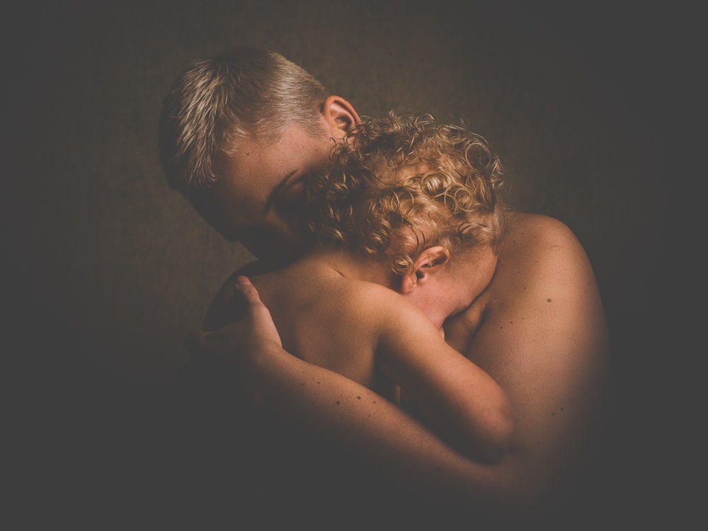 topless person carrying children