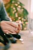 Healthy hands holding a warm cup of herbal infusion with blurred green garden background.