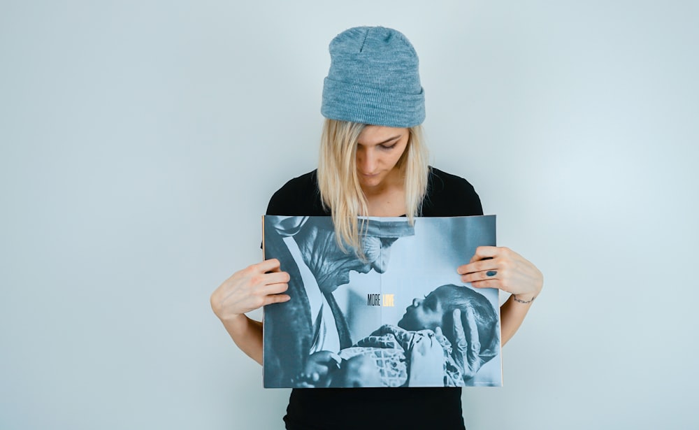 woman holding while looking to painting of man carrying baby