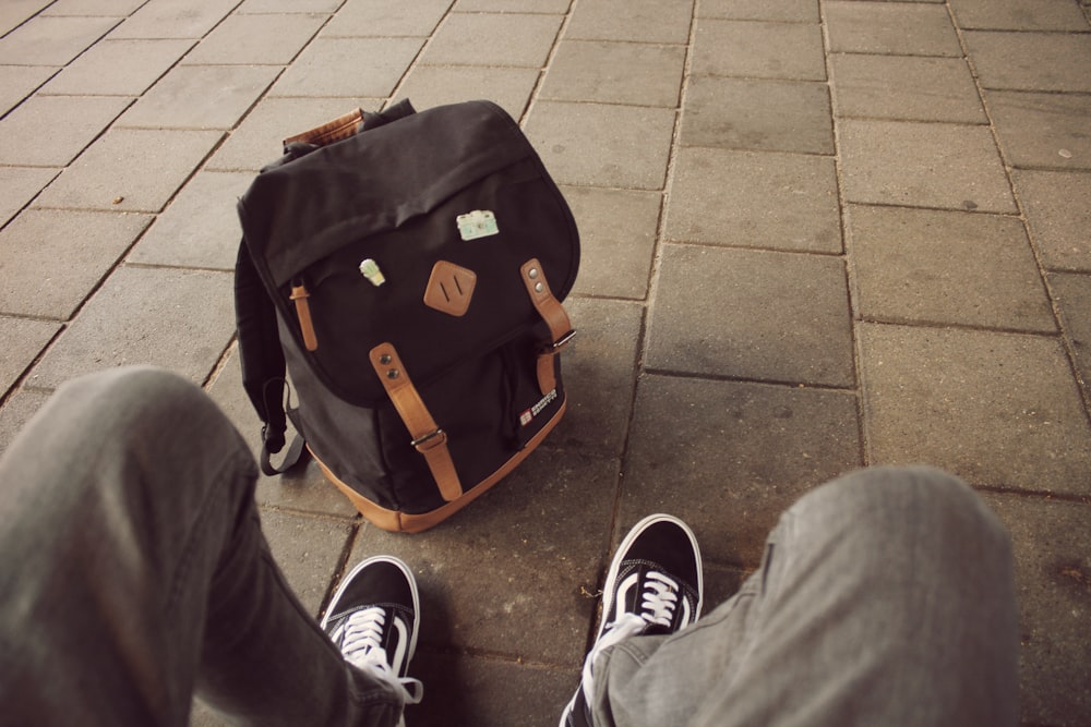 person wearing black-and-white Vans Old Skool sneakers