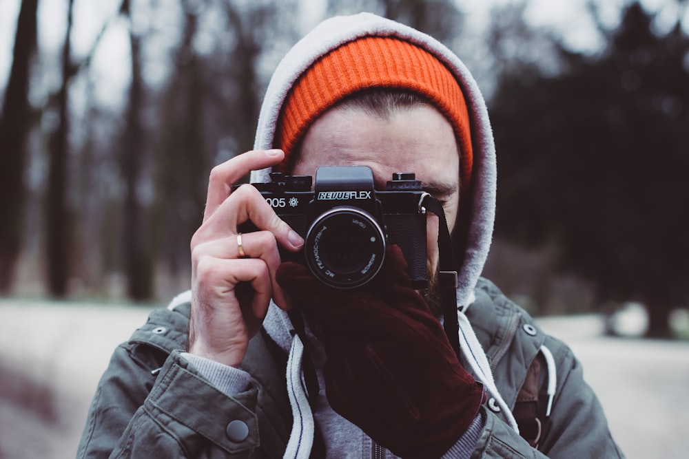 depth photography of man holding camera