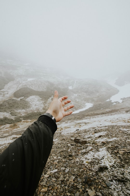 person rising their hand and facing at mountain in Ushuaia Argentina