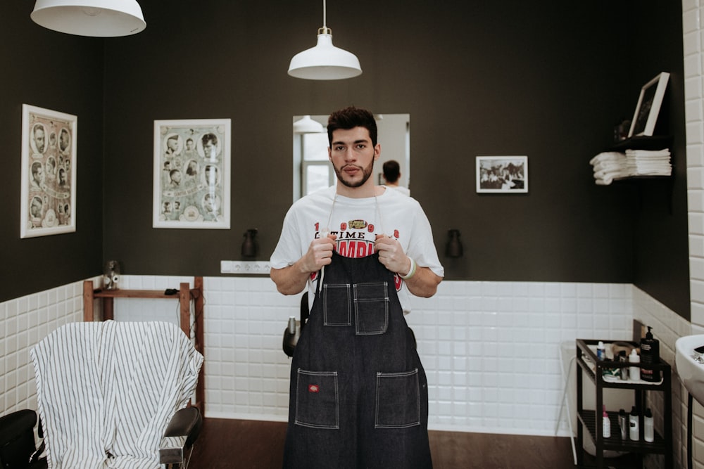 man in white T-shirt holding jumpsuit under pendant lamp