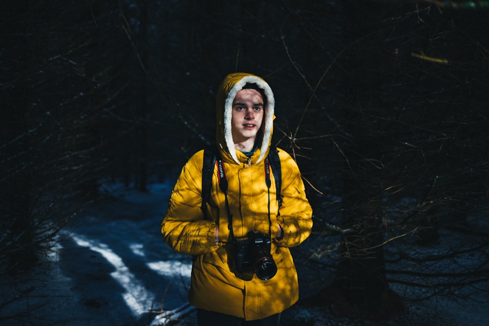 man wearing parka jacket and surrounded by trees