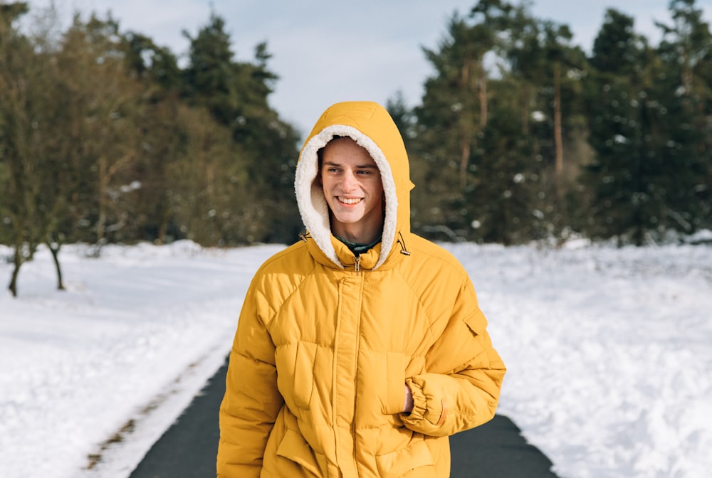 man standing on pathway in between snow field