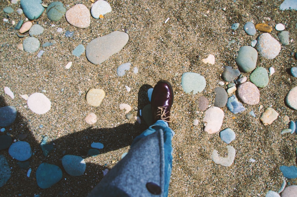 person showing unpaired maroon leather shoe