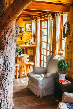 A sunlit, stylish homestay suite with warm wooden accents and plush seating.