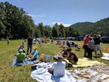 A group enjoying a day out picnic with scenic hills in the background.