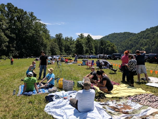 A group of happy travelers enjoying a picnic beside lush green valleys and winding rivers