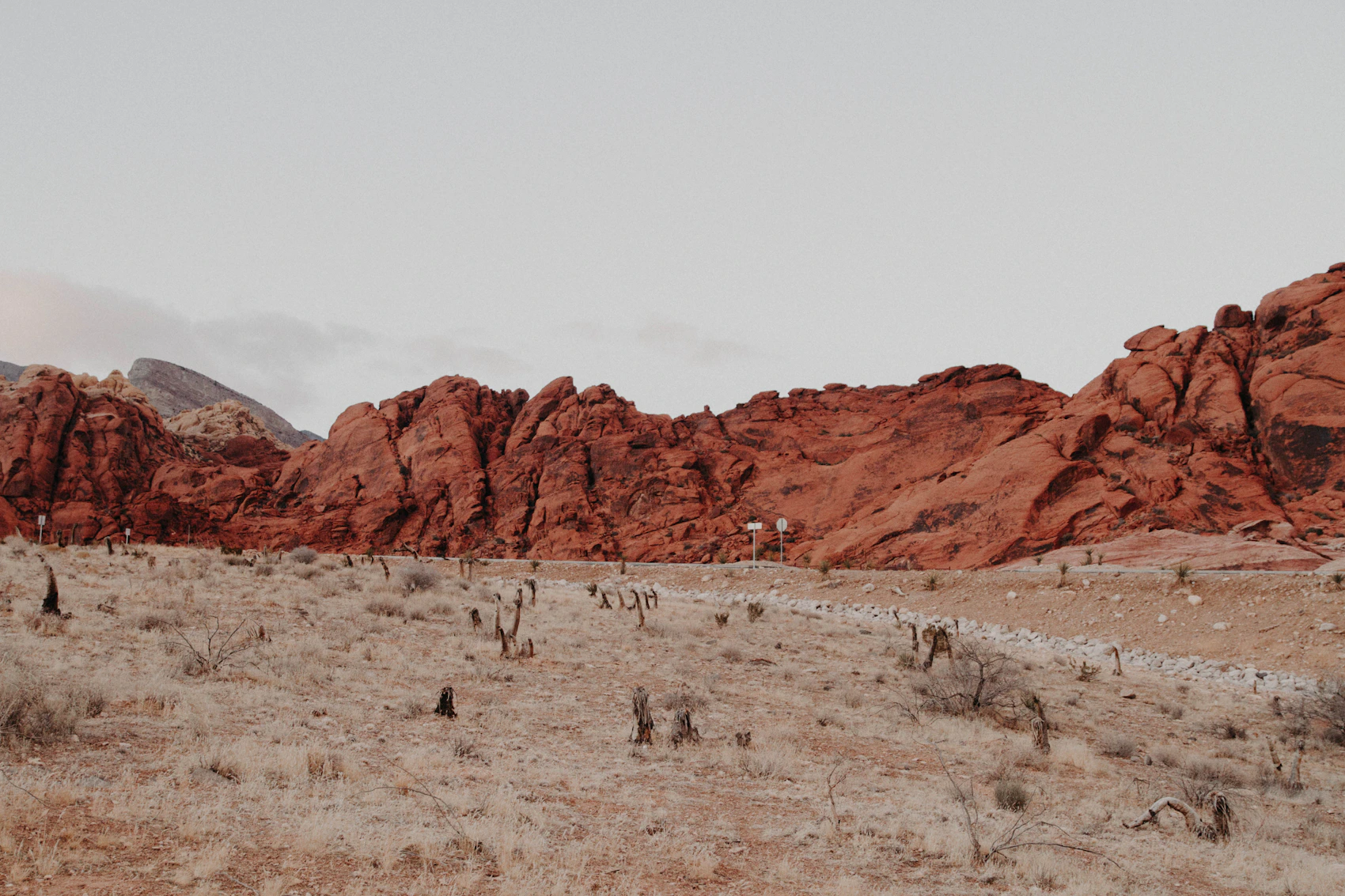 Red sandstone formations and pale desert near Las Vegas beneath a wide sky