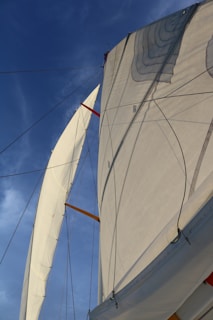 A close-up of a yacht's sail against a bright blue sky.