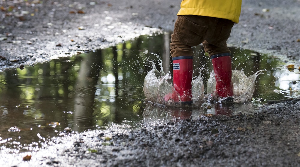 person in pair of red boots standing on water