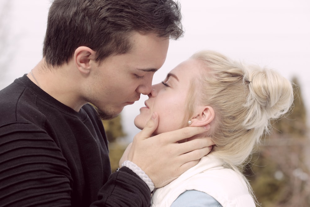 homme portant un haut noir sur le point d’embrasser une femme