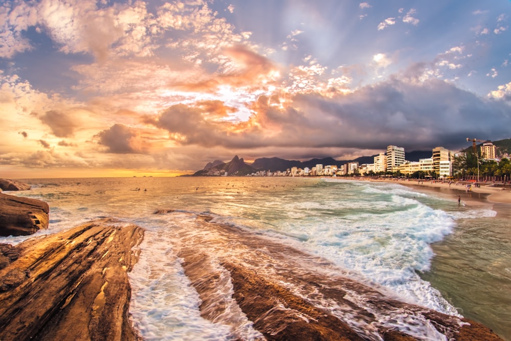 seashore near city under cloudy skies