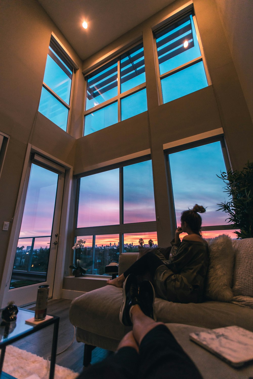 Una persona sentada en un sofá mirando por una ventana