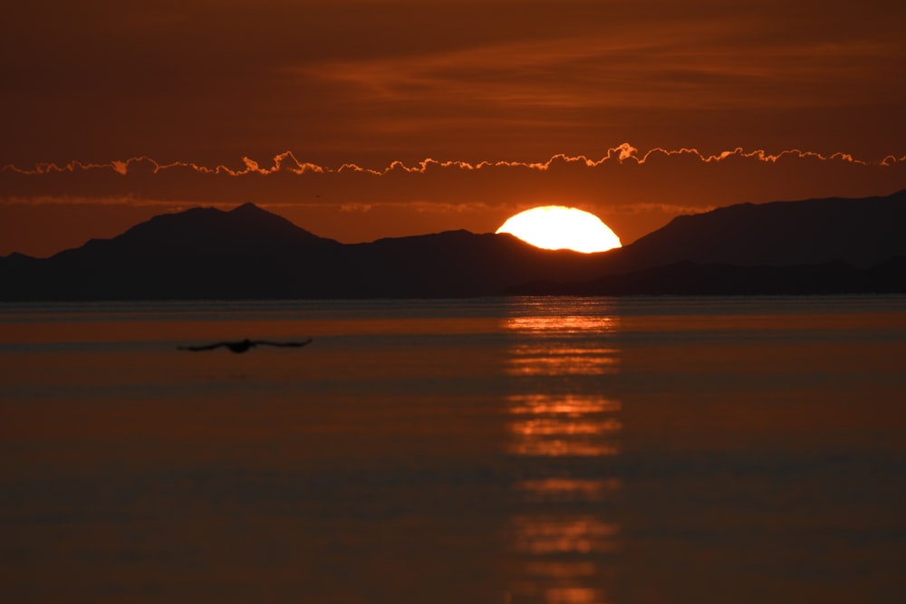 Photographie de silhouette de montagnes et de plan d’eau