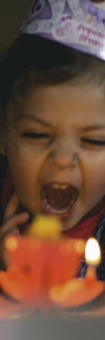 shallow focus photography of toddler blowing cake candles