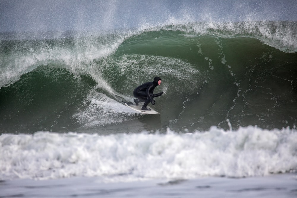 Person, die mit weißem Surfbrett surft