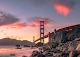 A group of Korean travelers enjoying a scenic overlook of the Golden Gate Bridge at sunset.