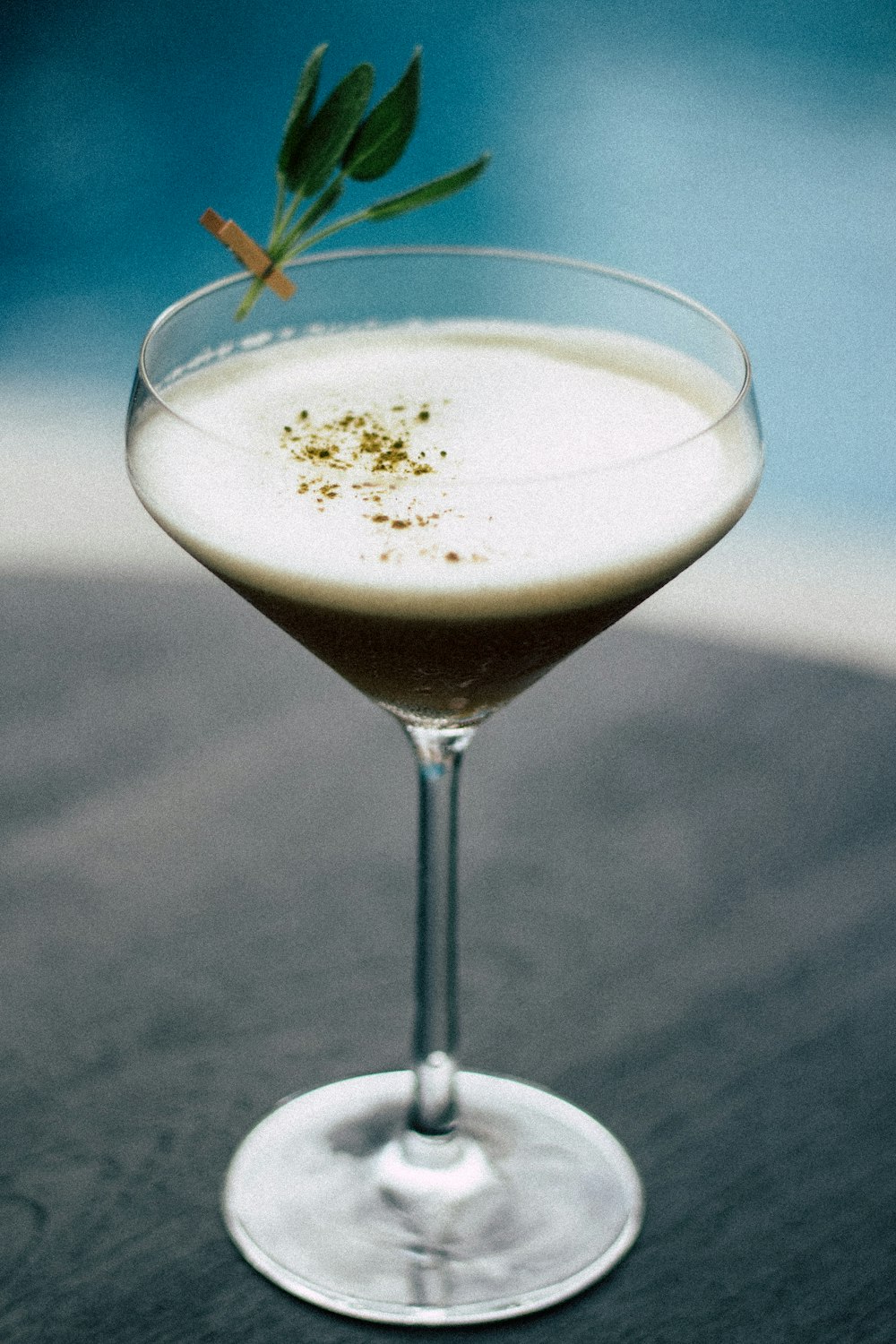 clear cocktail glass filled with brown liquid