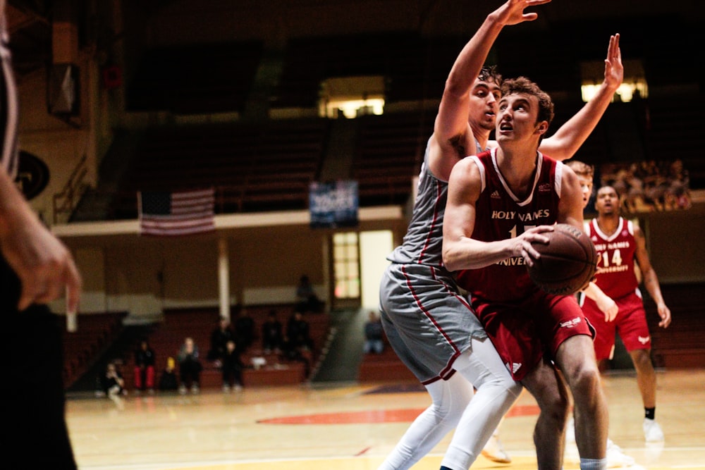 man in red jersey holding basketball