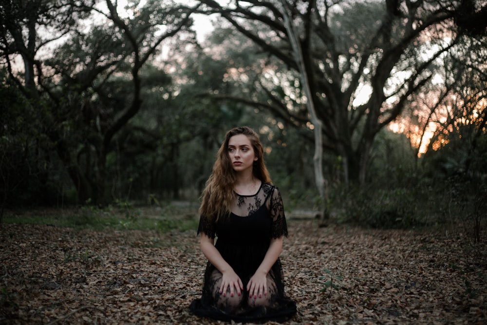 woman wearing black dress kneeling on ground