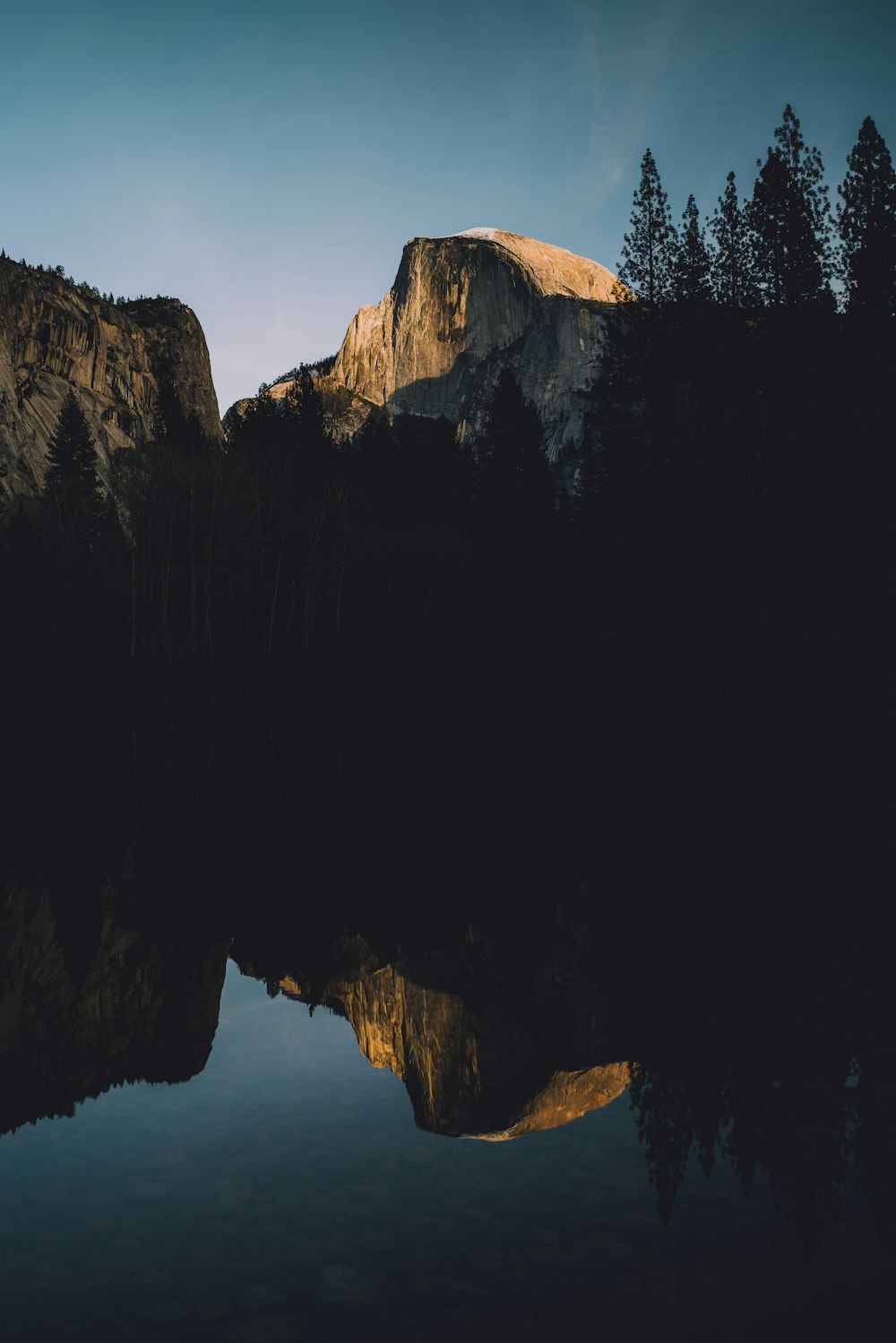 a mountain is reflected in the still water of a lake