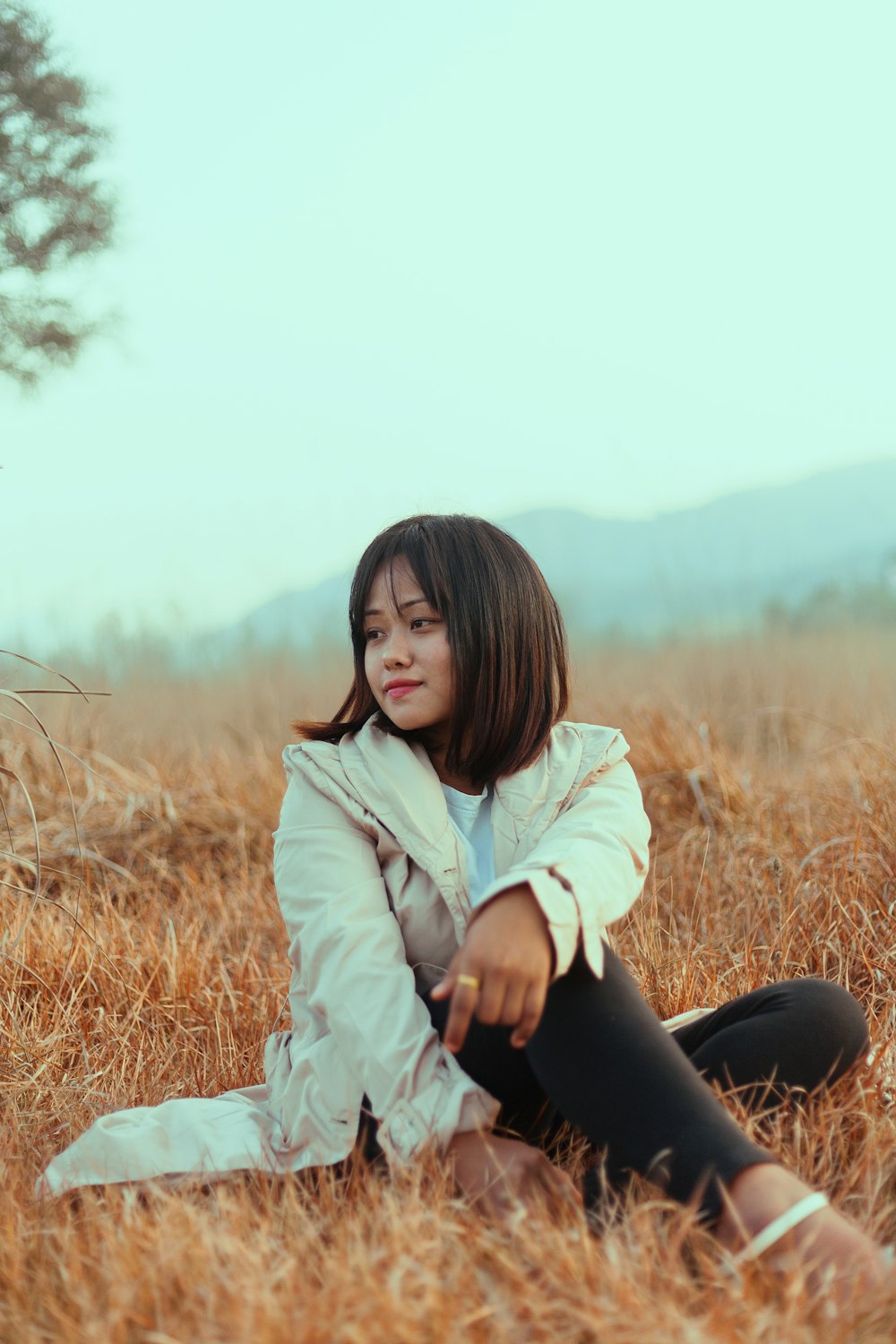 woman in jacket sitting on grass