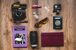 a table topped with a camera, passport, sunglasses and other items