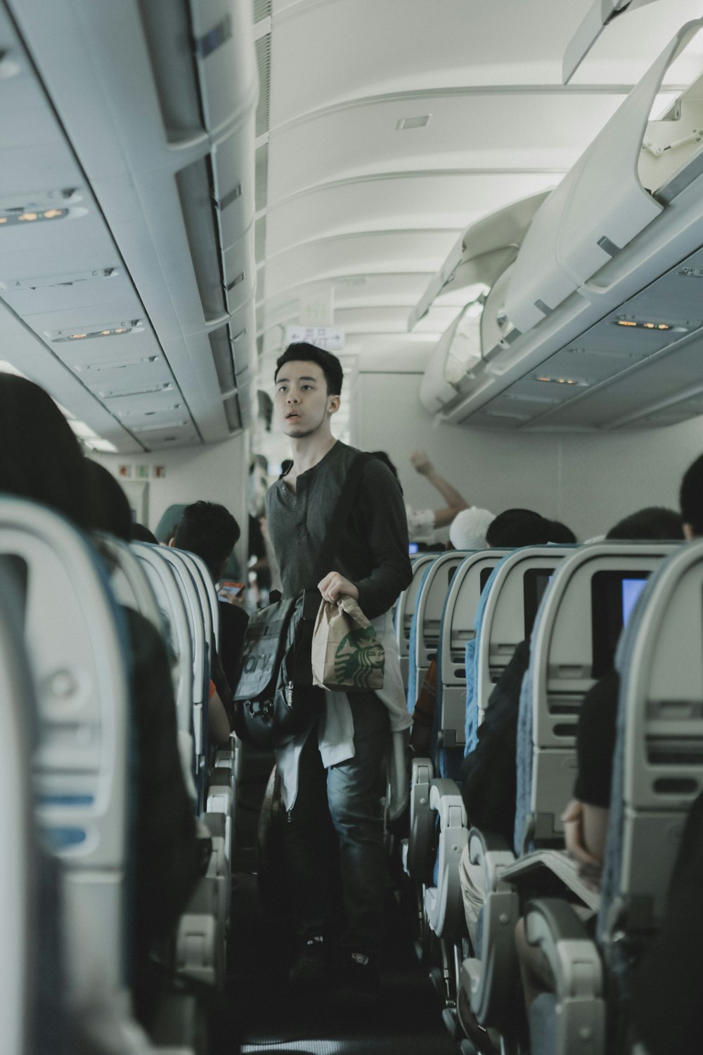 Mann hält Taschen im Flugzeug