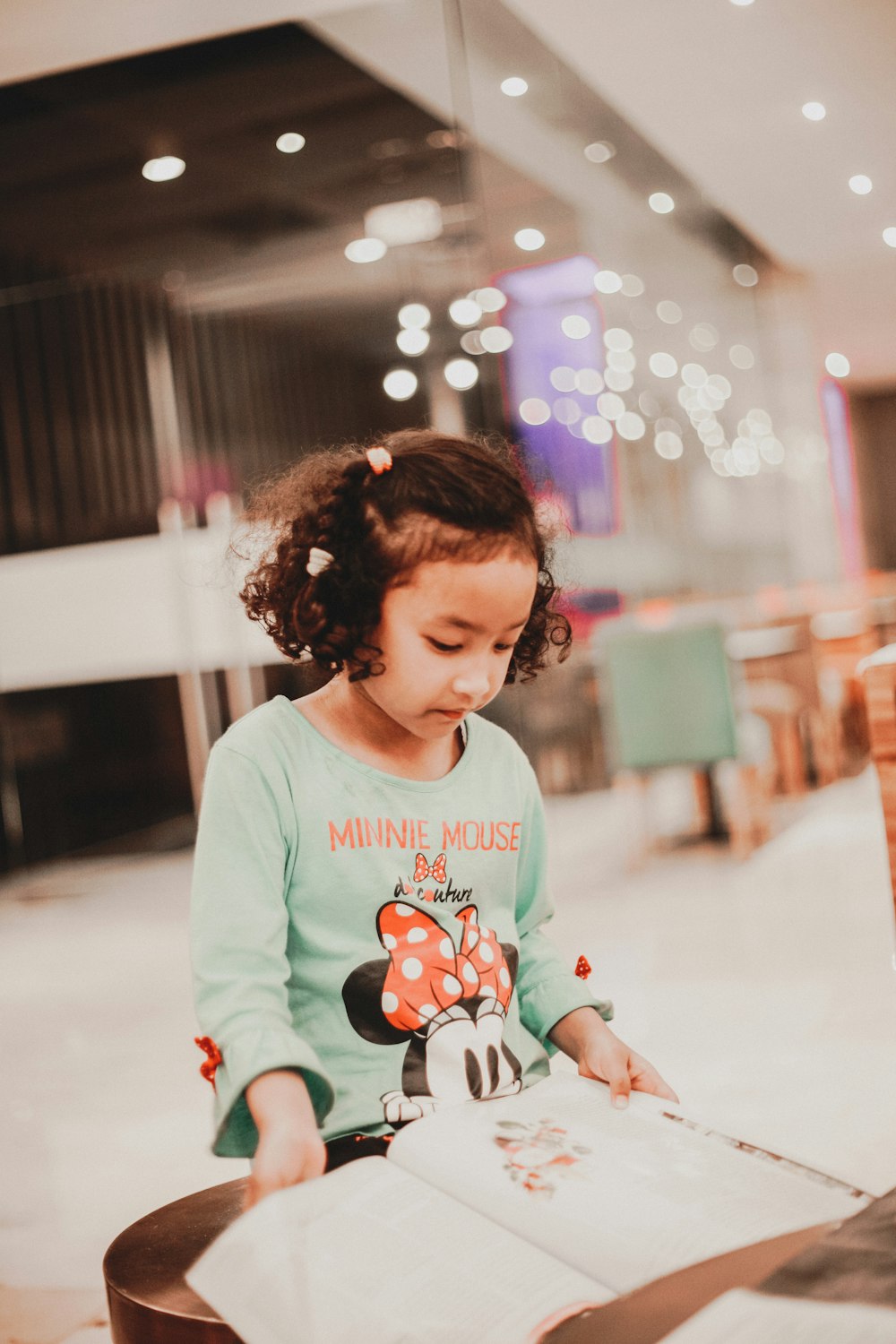 shallow focus photography of girl reading book