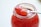 A jar of homemade fruit jam with a spoon beside it.