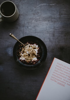 A serene morning scene with a journal, fitness tracker, and fresh fruit on a wooden table.