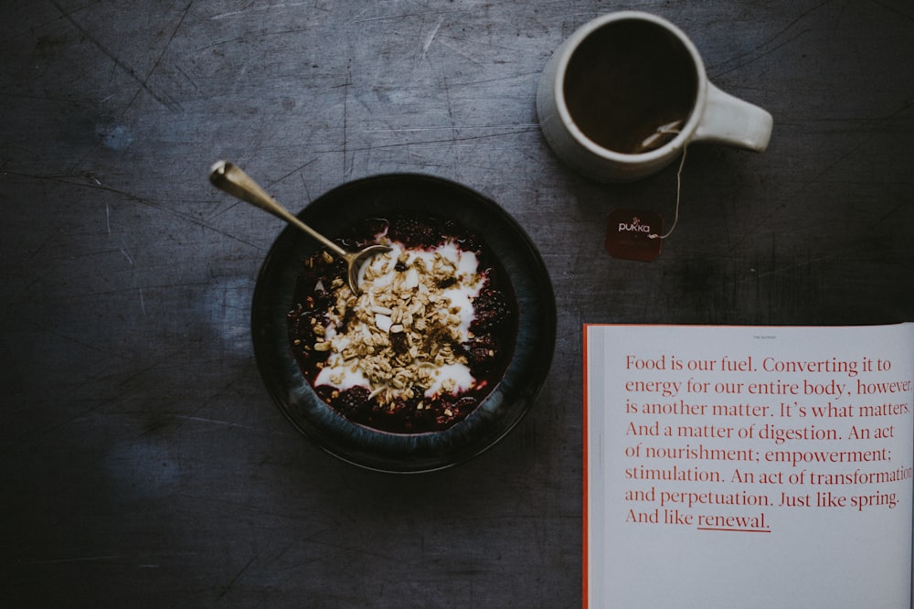 cereal in black bowl beside coffee cup