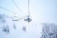 person riding cable train above snow covered field
