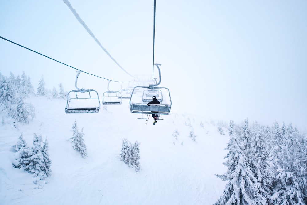 person riding cable train above snow covered field