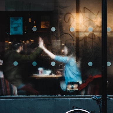 man and woman clapping each other hands inside the cafe