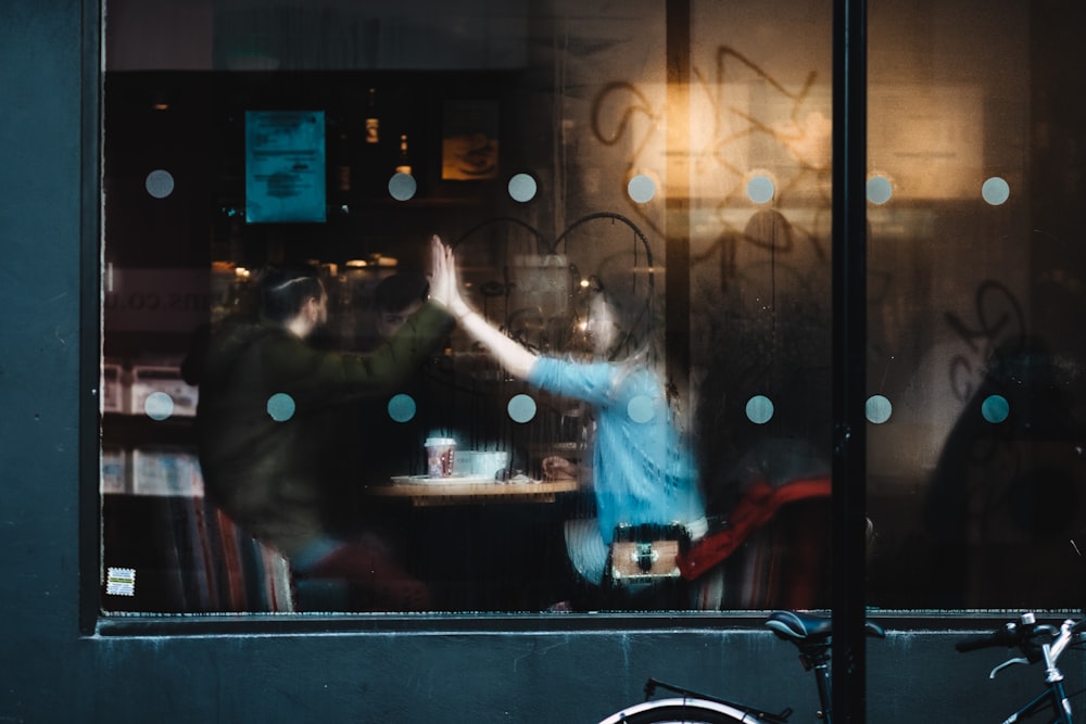 Homem e mulher batendo palmas dentro do café