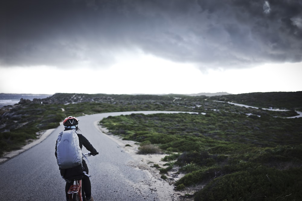 person riding bicycle near grass