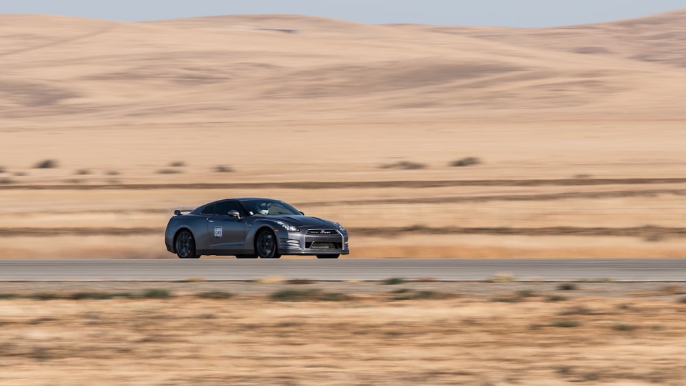 砂漠の道路を走行する日産GTR