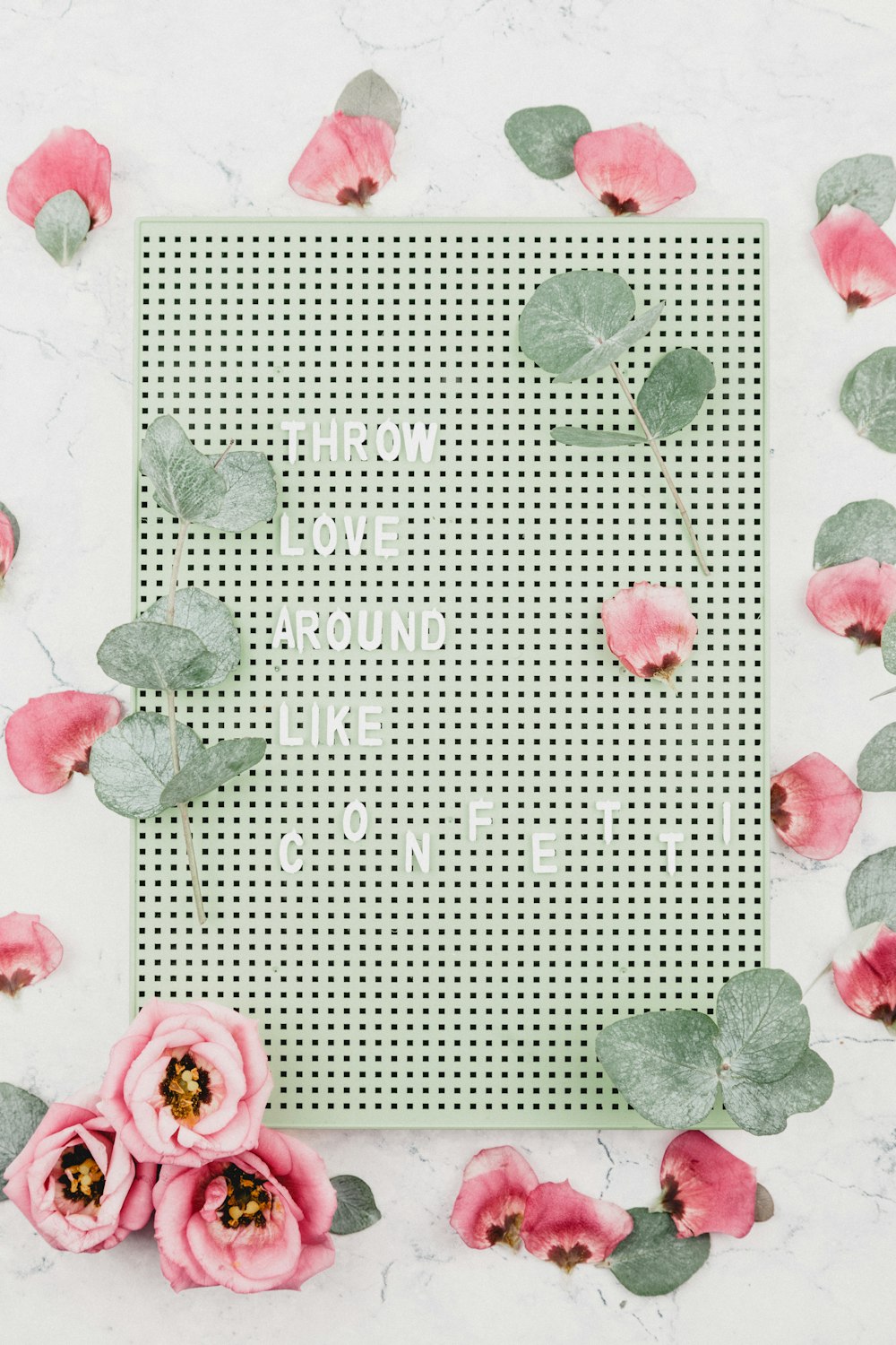 throw love around like confetti text on board surrounded b y flowers