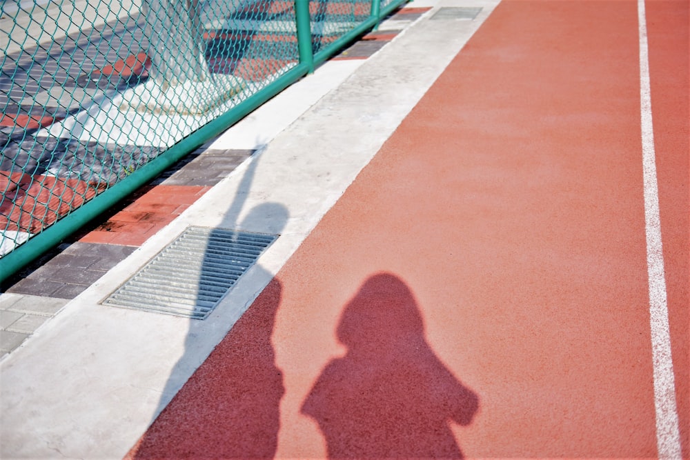 Schatten von zwei Personen auf brauner und roter Oberfläche